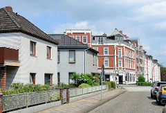 Kubische einstöckige Wohnhäuser - Fassade mit grauem Klinker verblendet; im Hintergrund Eckbebauung - Gründerzeit Wohnblock in Hamburg Wilstorf.