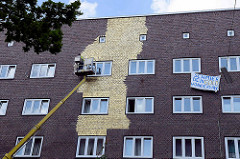Umstrittenes Kunstprojekt an einer Hauswand eines Wohngebäudes an der Veddeler Brückenstraße im Hamburger Stadtteil Veddel. 300 m² der Fassade wird von einem Hubwagen aus mit Blattgold belegt.