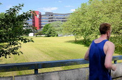 Fussgängerbrücke mit Jogger in der Hamburger City Nord.
