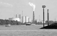 Blick über das Köhlbrand  / Süderelbe zum Kohlekraftwerk Hamburg Moorburg, eine Barkasse und ein Binnenschiff fahren auf der Elbe.