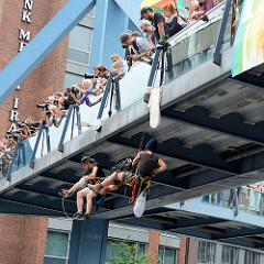 Demonstration am 08. Juli gegen G20 in Hamburg - zwei Demonstrant*innen seilen sich von einer Fussgänger-Brücke über der Willy Brandt Strasse ab - Fotografen.