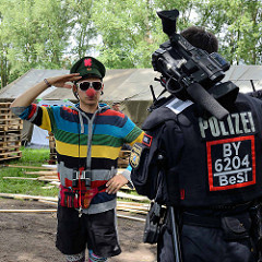 Umstrittenes G20 Protestcamp auf Entenwerder in Hamburg Rothenburgsort - ein politischer Clown mit roter Nase begrüßt einen Polizisten.