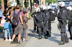 Colour the Red Zone - Protest gegen den G 20 Gipfel in Hamburg, Demonstanten in Sommerkleidung diskutieren mit Polizisten mit Helm und Kampfmontur.