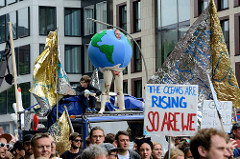Demonstration am 08. Juli gegen G20 in Hamburg - the oceans are RISING so are We - Demonstrantin in einer Filz-Erdkugel.