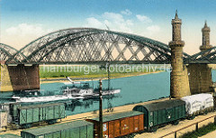 Altes Bild der Brücke über die Elbe bei Riesa; im Vordergrund Eisenbahnwaggons am Kai / Abdeckplane mit der Aufschrift Schott + Genossen, Glaswerk Jena. Ein Dampfschiff / Raddampfer, Ausflugsschiff Bodenbach fährt auf der Elbe flussaufwärts.