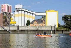 Industriearchitektur am Reiherstieg - Kaimauer und Silos; Gründerzeitvilla mit gelber Ziegelfassade; Motorboot der Feuerwehr.