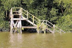 Alte Holztreppe / Wassertreppe am Prager Ufer im Hamburger Moldauhafen - das Ufer ist dicht mit Gebüsch und Weiden bewachsen.