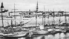 Historische Aufnahme vom Hafen in Riga; Segelschiffe in einem Hafenbecken - Blick zur Altstadt von Riga, Ufer der Düna - Petrikirche und Rigaer Dom.