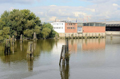 Panorama vom Moldauhafen im Hamburger Stadtteil Kleiner Grasbrook; lks, der Lagerschuppten G, in der Bildmitte Lagergebäude vom Übersee Zentrum; alte Holzdalben stehen im Hafenbecken.