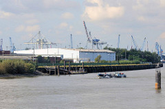 Lagergebäude an der Elbe beim Holthusenkai in Hamburg Kleiner Grasbrook - ein Tankschiff fährt elbaufwärts.
