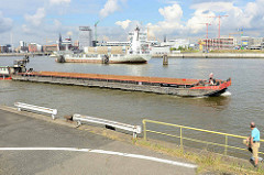 Ausblick vom Holthusenkai über die Elbe zum Kirchenpauerkai und Baustellen in der Hamburger Hafencity. Ein Schubschiff fährt elbaufwärts.