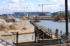 Baustelle am Baakenhafen in der Hamburger Hafencity - im Hintergrund die Glas- / Stahlkonstruktion der entstehenden Haltestelle / Bahnhof Elbbrücken.