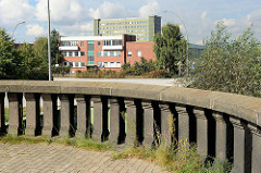 Ausblick von den Hamburger Freihafen-Elbbrücken zum Areal des ehem. Übersee-Zentrum auf dem Kleinen Grasbrook; im Vordergrund eine Steinbalustrade / Geländer bei der Freihafen Elbbrücke.