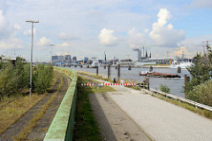 Ausblick vom Holthusenkai über die Elbe zur Hamburger Hafencity - ein Schubverband fährt elbaufwärts.