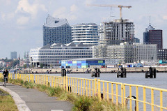 Metallgeländer am Holthusenkai an der Elbe auf dem Kleine Grasbrook - auf der gegeüber liegenden Elbseite die moderne Architektur und Kreuzfahrtterminal der Hamburger Hafencity.