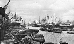 Altes Bild vom Kaiser-Wilhelm-Hafen in Hamburg - geschäftiges Treiben mit beladenen Schuten, Säcke,  Kisten, Ballen; Kräne und Dampfschiff am Kronprinzenkai - re. Frachtschiffe am Auguste Victoria Kai.