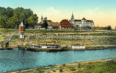 Historische Aufnahme vom Hafen in Torgau - Schiffe liegen am Ufer, Pegelturm und Panorama von Torgau mit Schloss Hartenfels.