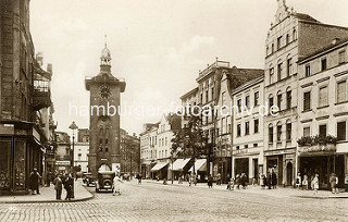 Historische Vorkriegsansicht vom Alten Markt in Elbing - Markttor und Geschäfte mit Markisen; Passanten auf dem Bürgersteig - parkende Autos.