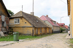 Traditionelle Architektur / Holzarchitektur - Holzhäuser an der Ģildes iela in Limbaži / Lemsal. Strasse mit Kopfsteinpflaster und schmalen Fußweg.