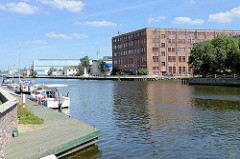 Blick über den Hafen in Elbląg / Elbing - Sportboote am Anleger, alte historische Industriearchitektur.