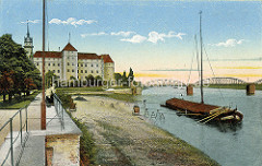 Historisches Foto von der Elbpromenade in Torgau - ein Elbkahn liegt vor Anker, Laufstege führen zum Ufer. Im Hintergrund Schloss Hartenfels und die Elbbrücke.