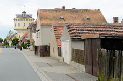 Wohnhäuser mit Garagen - Wasserturm von Strehla, errichtet 1907 - Planung Ingenieur C. Jensen; Nutzung bis in die 1980er Jahre.