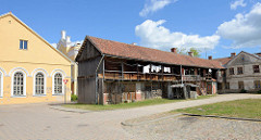 Rückseite der  ehem. Synagoge in Kuldīga / Lettland; in den 1950er Jahren zum Kino umgebaut, seit 2011 Sitz der Stadtbibliothek. Langer Holzschuppen mit Laubengang im Hinterhof.