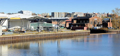 Industriegebiet, Gewerbe am Ufer der Bille in Hamburg Horn; Kaianlage mit Metall Spundwand - Lagerhäuser; im Hintergrund Wohnhäuser / Wohnblocks bei der Horner Landstraße.