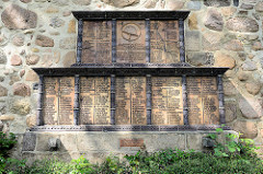Denkmal für die Gefallenen des I. Weltkriegs aus dem Kirchspiel Hittfeld - Den Vätern und Söhnen, die fürs Vaterland starben. Terrakotta-Tafeln mit Zierstäben an der Kirchenaussenwand der St. Mauritius.