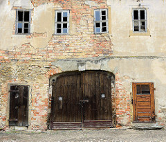 Altes Holztor - unverputzte Ziegelsteine und kaputte Fenster - Wirtschaftsgebäude vom Schloss Strehla.