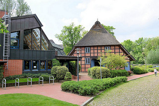 Moderner Neubau der Bücherei Meckelfeld - historisches Bauernhaus / Reetdachhaus / Fachwerkhaus im alten Dorfkern von Meckelfeld.