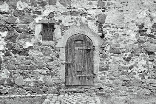 Alte Mauer, Holztür und vergittertes Fenster - Schloss Mühlberg / Elbe.