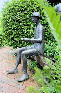 Bronzeskulptur Der Leser an der Bücherei in Meckelfeld; Bildhauer / Künstler Ulrich Heitmüller-Schimmel, 1982.