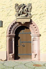 Eingang vom historischen Gebäude der im 15. Jahrhundert errichteten Stadtschule / Rektorat. Wappen - Relief von St. Georg über der Eingangstür.