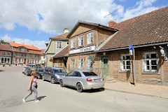Historische Innenstadt von Kuldīga, alte Holzhäuser - parkende Autos.