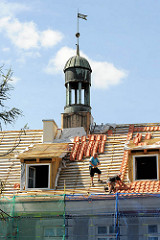 Handwerker beim Restaurieren eine Gebäudes in Elbląg / Elbing, Dachdecker bei der Arbeit.