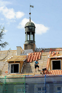 Handwerker beim Restaurieren eine Gebäudes in Elbląg / Elbing, Dachdecker bei der Arbeit.