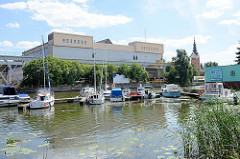 Blick über die Marina am Fluss Elbląg / Elbing zu Industrieanlagen am Hafen - re. der Kirchturm der katholischen St. Nikolaikirche.