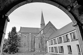 Blick durch einen Torbogen zur Klosterkirche Marienstern in Mühlberg / Elbe. Das Zisterzienserinnenkloster wurde 1228 gegründet; die einschiffige Klosterkirche ist ein gotischer Backsteinbau mit romanischen Elementen.