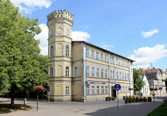 Neogotische Architektur - freistehender Turm mit Zinnen; Apothekengebäude in Kuldīga