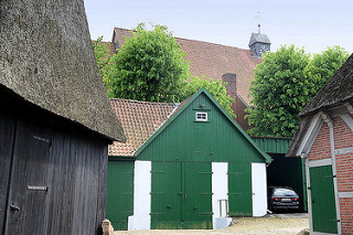 Alter Dorfkern von Hittfeld - landwirtschaftliche Gebäude, im Hintergrund das Kirchenschiff der St. Mauritius Kirche.