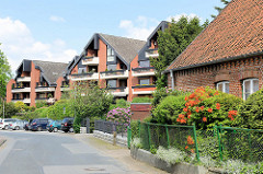 Moderne Wohnhäuser - Architektur der 1980er Jahre - altes Backsteingebäude mit blühenden Azaleen im Vorgarten - Bilder aus Hittfeld / Seevetal.