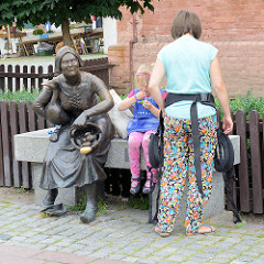 Marktfrau - Bronzeskulptur auf einer Bank, Marktplatz in Toruń - Platz Rynek Nowomiejski, Bildhauer Anety + Macieja Jagodzinskich-Jagenmeer 2011.