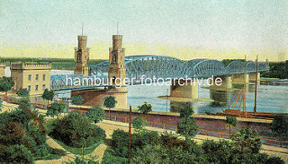 Historische Ansicht der Eisenbahnbrücke über die Weichsel bei Toruń - Backsteingebäude, gelbe Ziegel; Schiffe am Weichselufer.