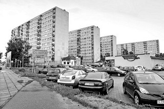 Hochhäuser, Plattenbauten und Parkplatz vor einem Supermarkt - Jeśmanowicza Leona in Toruń.