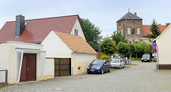 Wohnhäuser, Schuppen - Garage an der Mühlenstraße in Belgern - im Hintergrund der Turm vom ehem. Klosterhof.