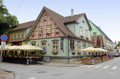 Landestypisches Holzhaus - Eckgebäude mit Fachwerkgiebel, Restaurant mit Terrassen am Strassenrand - Architektur in Pärnu, Estland.