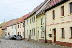 Straße / Fußweg mit Kopfsteinpflaster - geschlossene Wohnbebauung, einstöckige Wohnhäuser mit Satteldach; Fotos aus Schildau.
