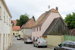 Historische Wohnhäuser mit Spitzdachschuppen / Holgiebel; Blick durch die Beethovenstraße zur St. Marienkirche in Schildau.