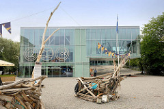 Gebäude der Öffentlichen Bücherei, Zentralbibliothek, / Keskraamatukogu in Pärnu - Holzskulpturen auf dem Vorplatz.